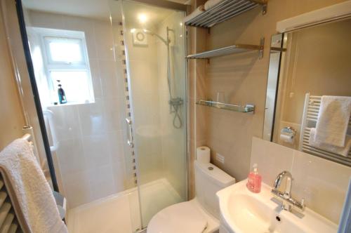 a bathroom with a shower and a toilet and a sink at 3 The Promenade in Sheringham