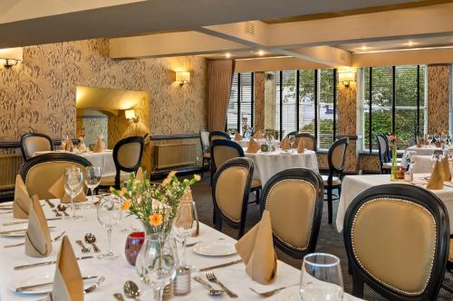 a dining room with tables and chairs with white tablecloths at Mariners Hotel in Haverfordwest