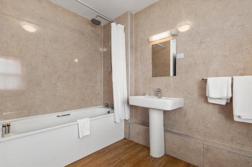 a bathroom with a sink and a bathtub and a sink at Hotel Mariners in Haverfordwest