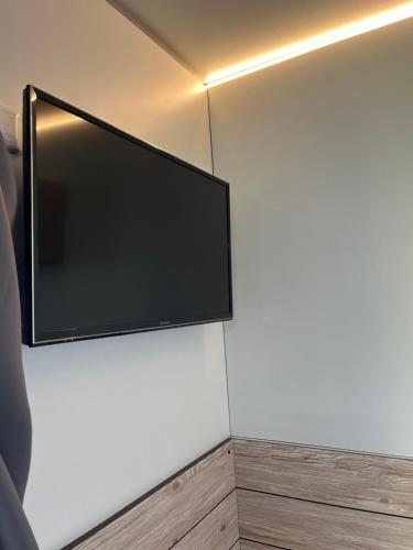 TV de pantalla plana colgada en la pared en Hostel Stover, en Löningen