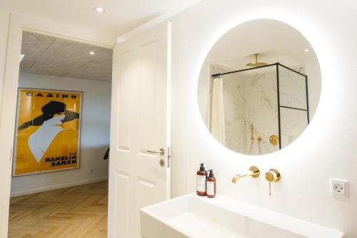 a bathroom with a white sink and a mirror at STAY Penthouse in Kolding