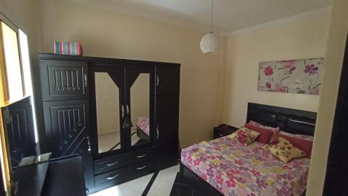 een slaapkamer met een bed en een dressoir met een spiegel bij alloggio in Agadir