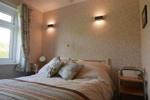 ein Schlafzimmer mit einem Bett mit zwei Kissen und einem Fenster in der Unterkunft 35 Siesta Mar in Mundesley