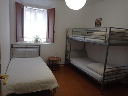 Ce dortoir comprend 2 lits superposés et une fenêtre. dans l'établissement Alojamiento Oviedo 1, à Oviedo