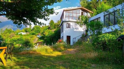 a house with a view of the yard at Homestay Nature Auli in Joshīmath