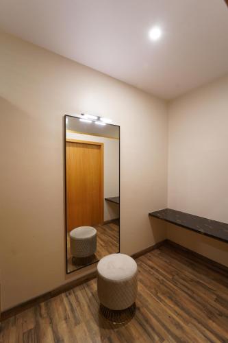 ein Ankleidezimmer mit einem Spiegel und einem Stuhl in der Unterkunft Dvr Mansion in Kurnool