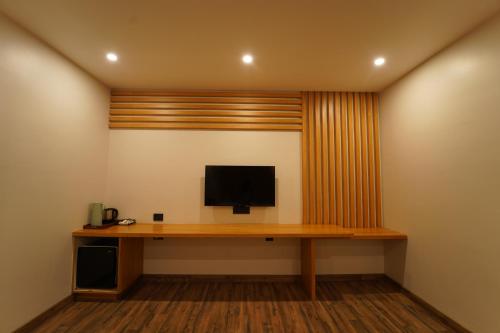 a room with a desk with a television on a wall at Dvr Mansion in Kurnool