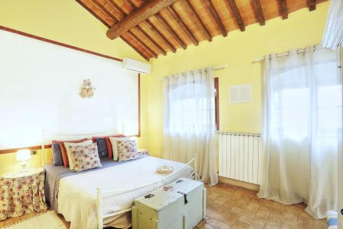 a bedroom with a bed and a large window at Podere Il Belvedere su Cortona in Castiglion Fiorentino