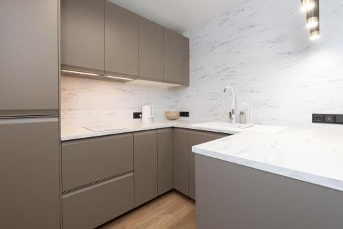 uma cozinha com paredes de mármore branco e bancadas brancas em Two-Story Urban Gem em Talin