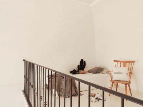 a person laying on a bed next to a chair at Palazzo dei Gigli Puglia - house with heatable rooftop-Pool in Ugento