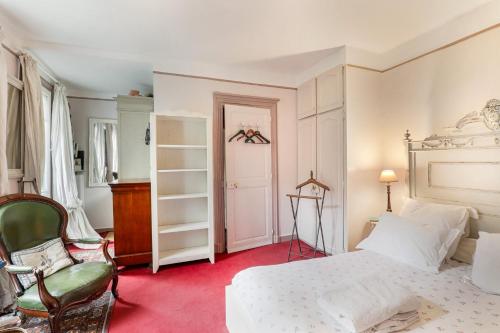 sypialnia z białym łóżkiem i krzesłem w obiekcie "Maison 1850 Paris 18" Chambre avec terrasse et parking en option w Paryżu