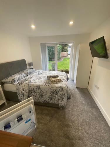 Schlafzimmer mit einem Bett und einem Kühlschrank in der Unterkunft Selborne Studios - Breakfast included in Parkside