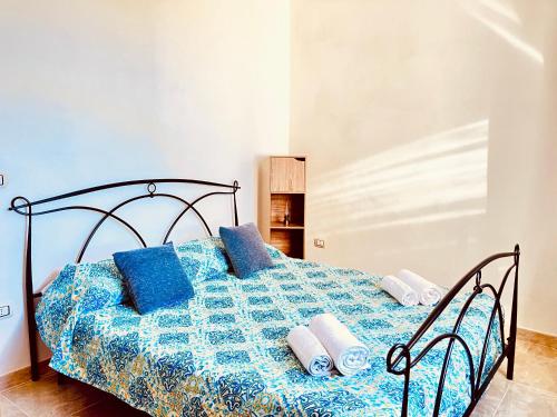 un letto con cuscini blu sopra di Newly renovated apartment in the heart of Sorso a Sorso