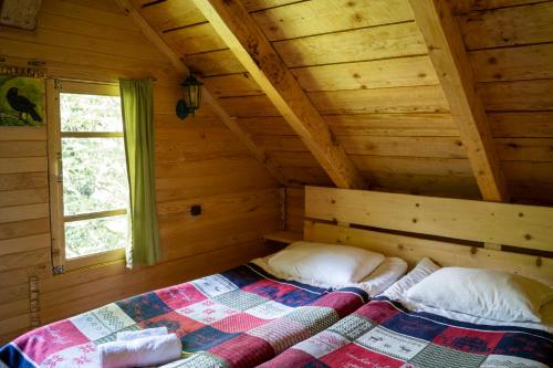 ein Schlafzimmer mit einem Bett in einer Holzhütte in der Unterkunft Mestia Eco Huts 2 in Mestia
