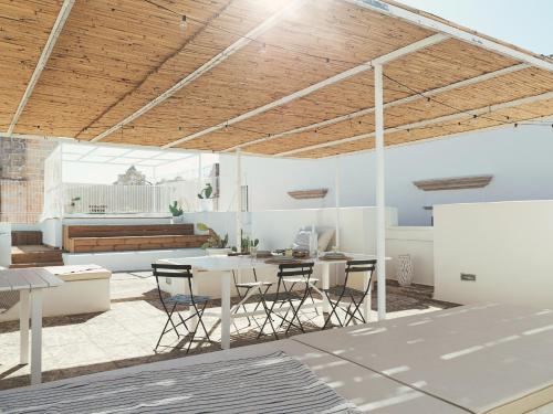 an open living room with a table and chairs at Palazzo dei Gigli Puglia - house with heatable rooftop-Pool in Ugento