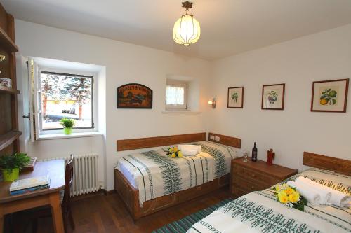 een slaapkamer met 2 bedden, een bureau en een raam bij Chalet San Valentino - Happy Rentals in Livigno