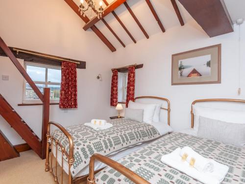 a bedroom with two beds and a window at Majestic Farmhouse Barn 8 Guests Pass the Keys in Pudsey