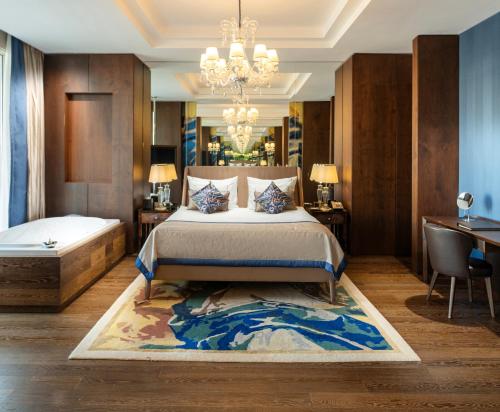 a bedroom with a bed and a chandelier at Kaya Palazzo Resort & Casino in Kérynia