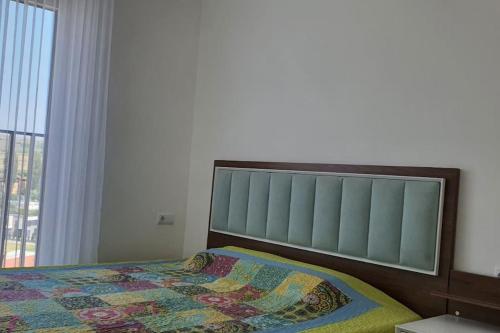 - un lit avec une couette dans une chambre dans l'établissement Perfect Place for Your Vacation, à Gnjilane