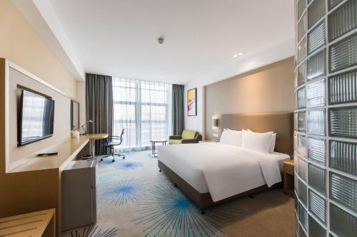 a hotel room with a white bed and a desk at Holiday Inn Express - Liuyang Development Zone, an IHG Hotel in Liuyang