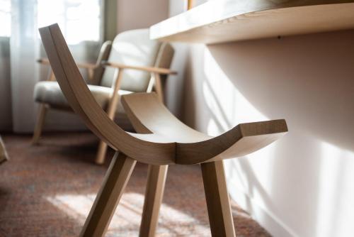 a wooden chair sitting next to a table at Serra Boutique Hôtel in Agen