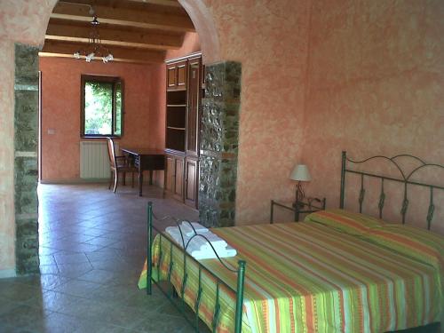 a bedroom with a bed and a table in a room at Società Agricola MG Florplant in Francavilla Marittima
