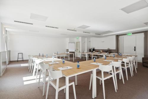 a large room with a long table and white chairs at Hôtel de la Couronne in Morges