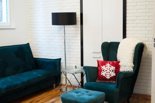 - un salon avec deux chaises vertes et un oreiller rouge dans l'établissement Apartament Centrum Legnicy Janson, à Legnica