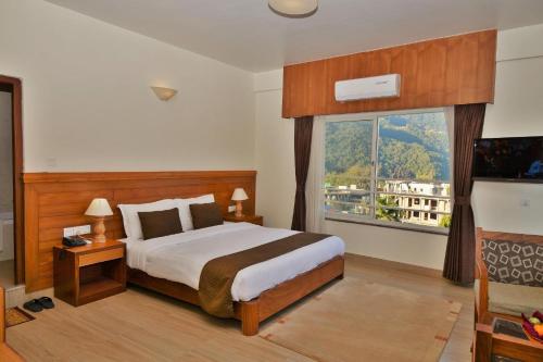 a bedroom with a bed and a large window at Mount View Pokhara in Pokhara
