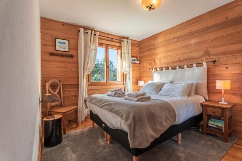 - une chambre avec un grand lit et des murs en bois dans l'établissement Beautiful 2 bed Chalet Morzine, à Morzine