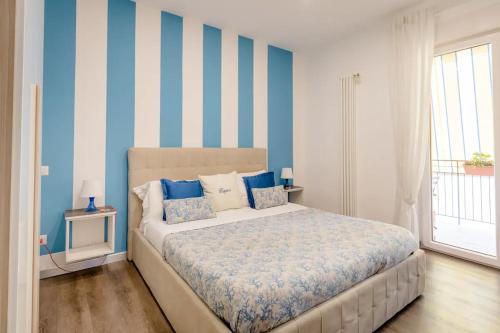 1 dormitorio con 1 cama con rayas azules y blancas en B&B Il Saraceno, en Sorrento