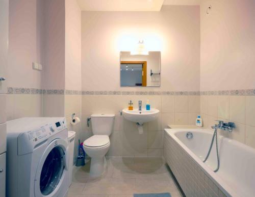 a bathroom with a washing machine and a toilet and a sink at Ursynow Apartament WAW Lanciego in Warsaw
