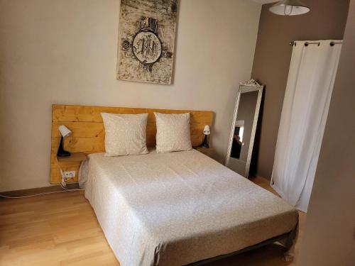 a bedroom with a bed and a clock on the wall at Souvenirs d'hier in Hyères