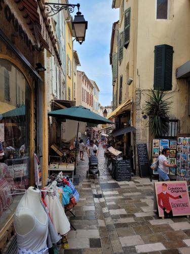 a street with shops and people walking down a street at Souvenirs d'hier in Hyères