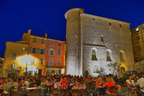 a group of people sitting at tables in front of a building at Souvenirs d'hier in Hyères