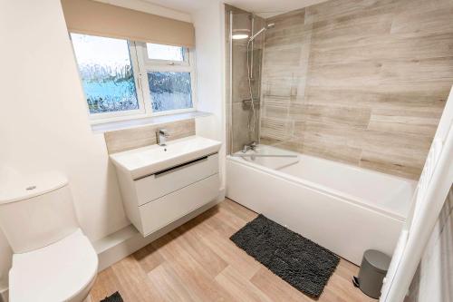 a bathroom with a sink and a toilet and a bath tub at Newly Renovated Rural Cottage in North Scarle in Lincoln