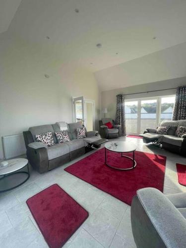 a living room with a couch and a red rug at Runway Retreat in Carrickmore