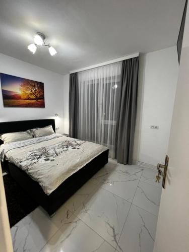 a bedroom with a bed and a large window at Cozy place in Baia Mare
