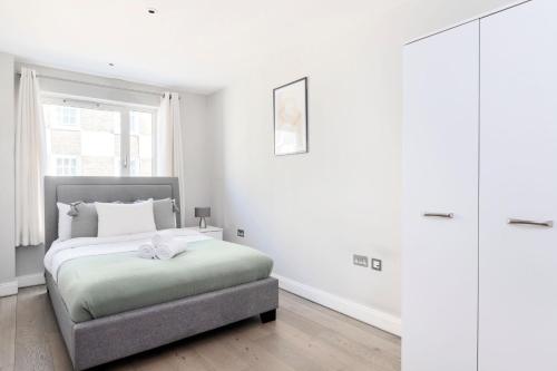 una camera bianca con un letto e una finestra di Westminster Abbey - CityApartmentStay a Londra