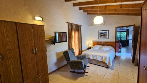 un dormitorio con una cama y una silla en Cabaña de Encanto, en San Rafael