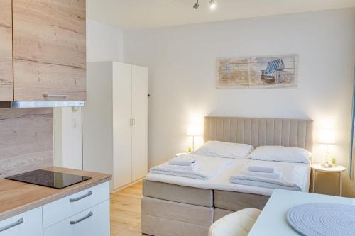 een kleine slaapkamer met een bed en een keuken bij Wohnen auf Zeit - Studiowohnung Innsbruck in Innsbruck