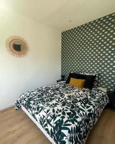 Schlafzimmer mit einem Bett und einem Wandspiegel in der Unterkunft Studio 2 personnes - Bouleries Jump - 24H du Mans in Parence