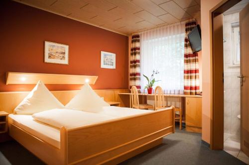 a bedroom with a bed and a table and a window at Landgasthof Linden in Linden