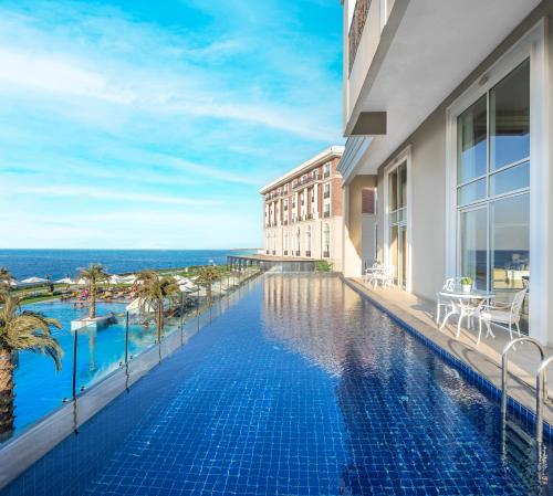 a hotel swimming pool with a view of the ocean at Kaya Palazzo Resort & Casino in Kérynia