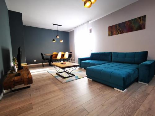 een woonkamer met een blauwe bank en een tafel bij Serenity Suite in Sinaia
