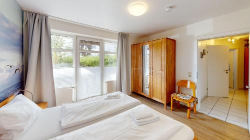 a bedroom with two white beds and a window at Grüntal-Residenz Haus II App. 2 in Grömitz