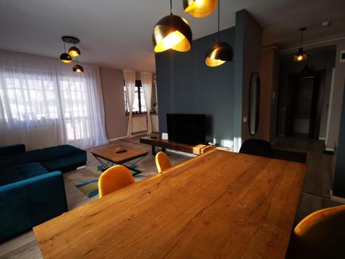 a living room with a wooden table and a blue couch at Serenity Suite in Sinaia