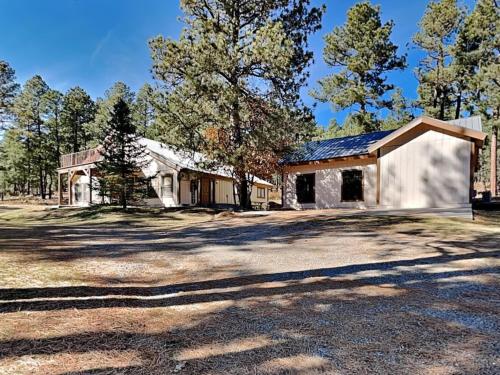 a large white house with trees in the background at Quiet Mountain Hideaway in Alto