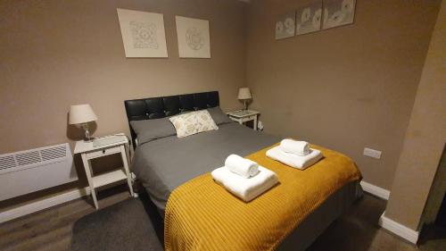a bedroom with a bed with towels on it at The Savile, Luxury Apartment Leeds - Your Next Stay in Leeds