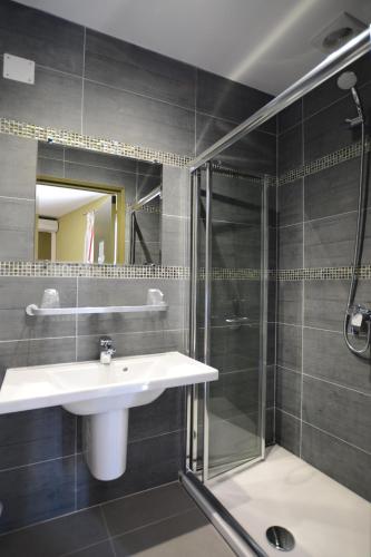 a bathroom with a sink and a shower at Hôtel la Palma in Patrimonio